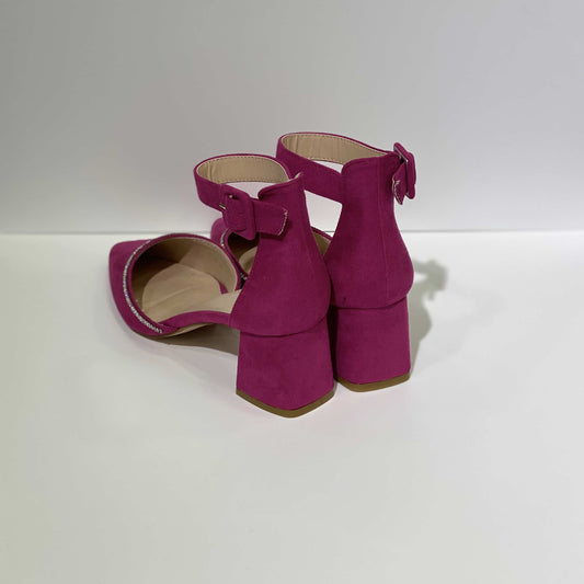 Vista posteriore di décolleté in camoscio fucsia con cinturino regolabile, tacco largo e finiture eleganti.