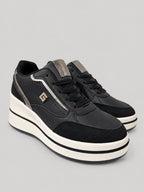 Sneakers TIA, colore nero, vista di tre quarti: punta arrotondata e finitura con pannelli a contrasto.