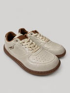 Sneakers UNA, colore beige, vista di tre quarti: punta arrotondata e finitura con pannelli a contrasto.