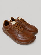 Sneakers UNA, colore marrone, vista di tre quarti: punta arrotondata e finitura con pannelli a contrasto.