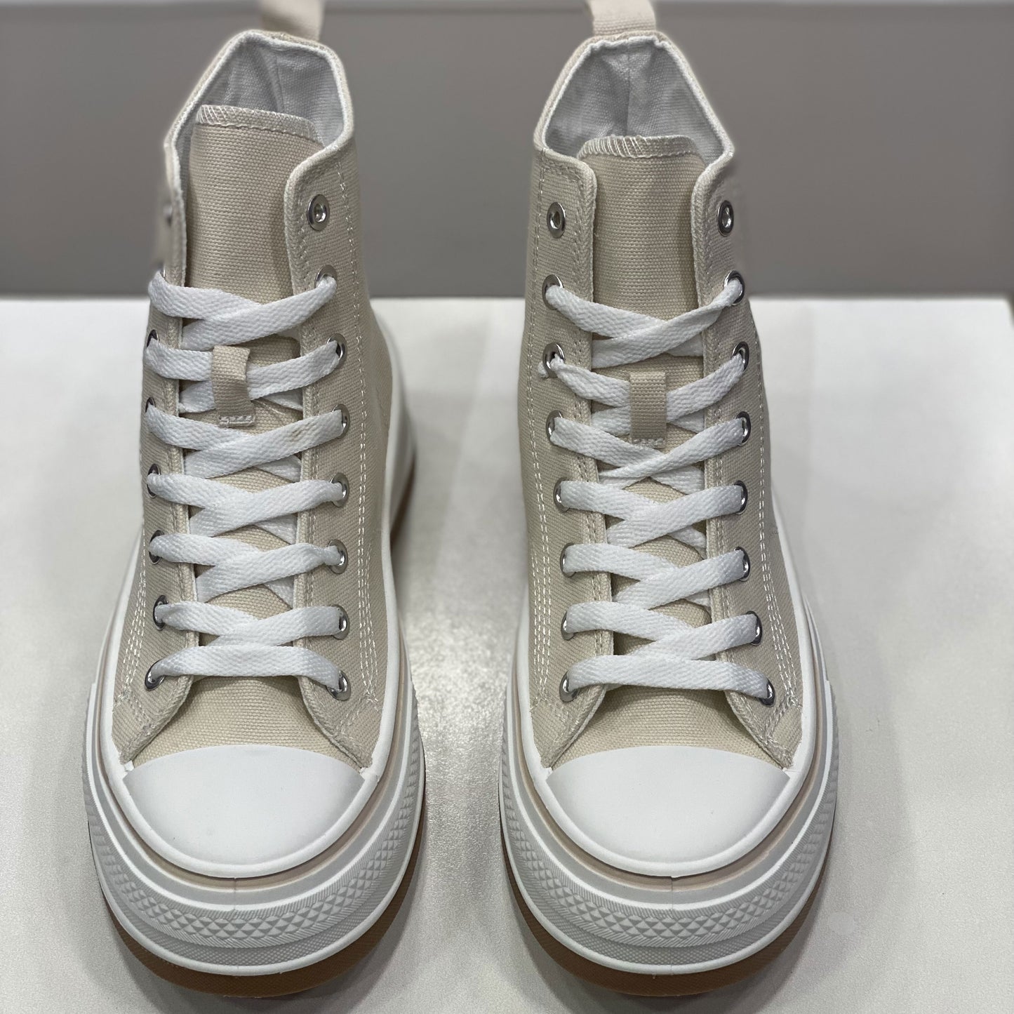 Sneakers alta beige in tela con suola alta, vista frontale su sfondo neutro