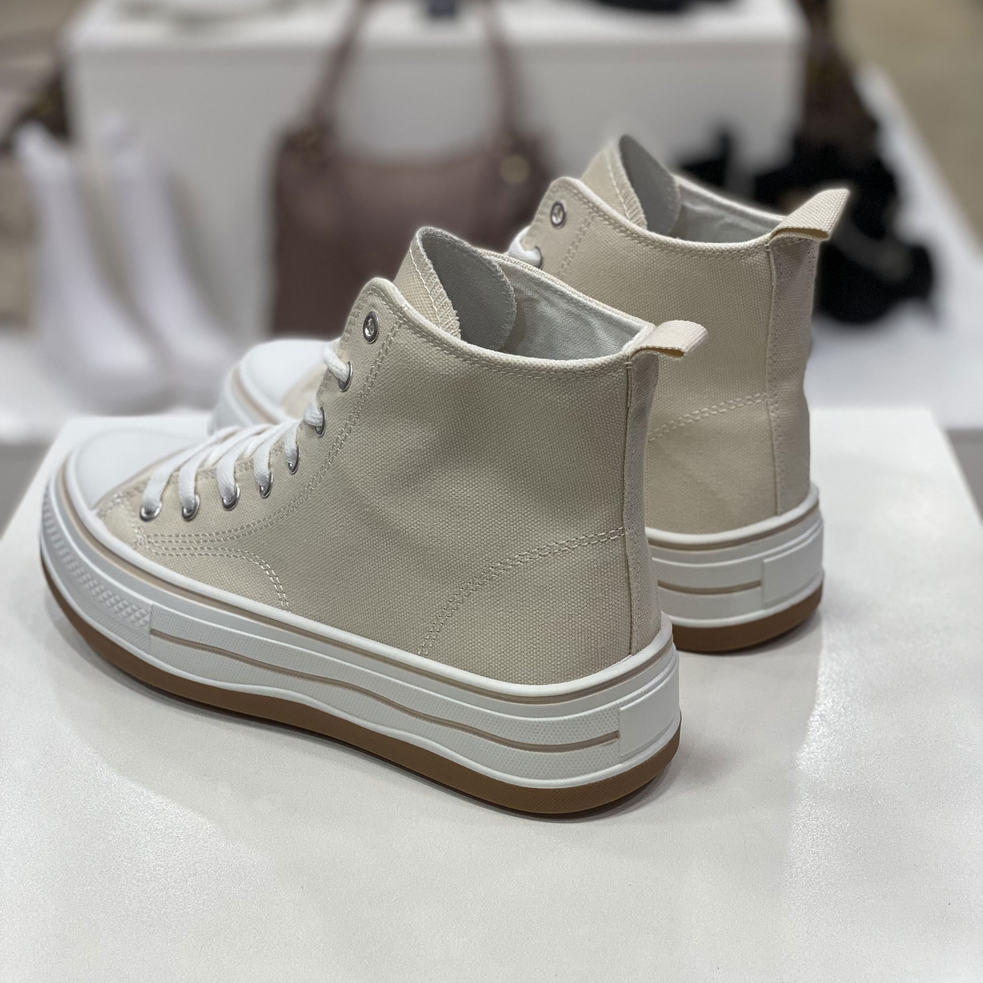 Sneakers alta beige in tela con suola alta, vista posteriore per evidenziare il design del tallone