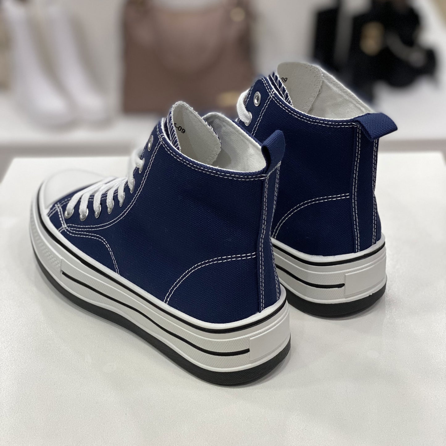 Sneakers alta blu in tela con suola alta, vista posteriore per evidenziare il design del tallone