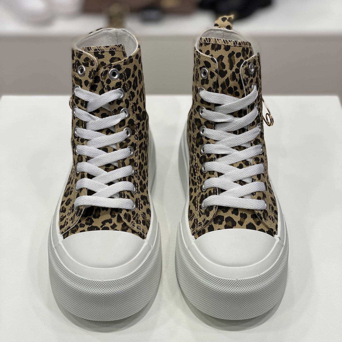 Sneakers alte leopardate con spilla dorata applicata, vista frontale per evidenziare il design selvaggio e originale