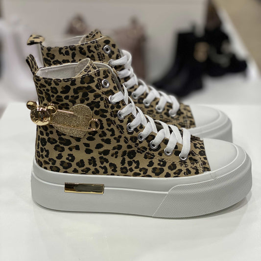 Sneakers alte con fantasia leopardata e spilla dorata a forma di cuore e orsetto, vista laterale su sfondo neutro