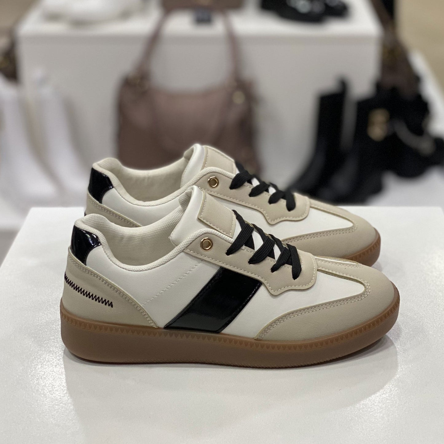 Sneakers beige e bianche con suola in gomma, vista laterale per mostrare i dettagli del design