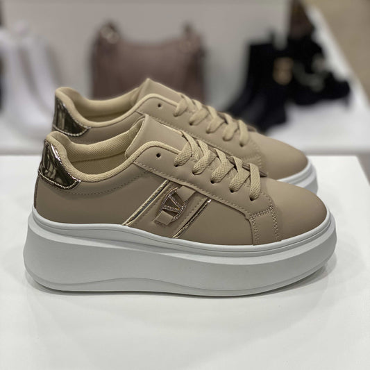 Sneakers beige con dettagli dorati e suola alta bianca, vista laterale per mostrare il design sofisticato
