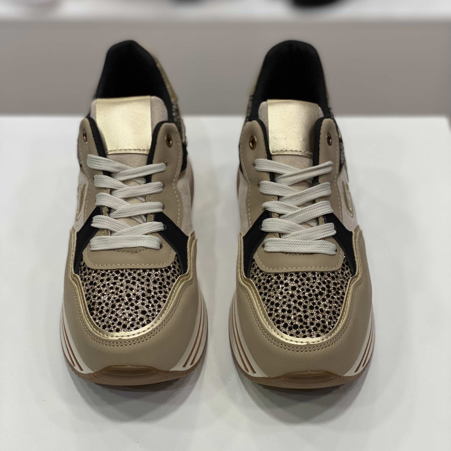 Sneakers beige con glitter e rifiniture dorate, vista frontale su sfondo neutro per mostrare il design accattivante