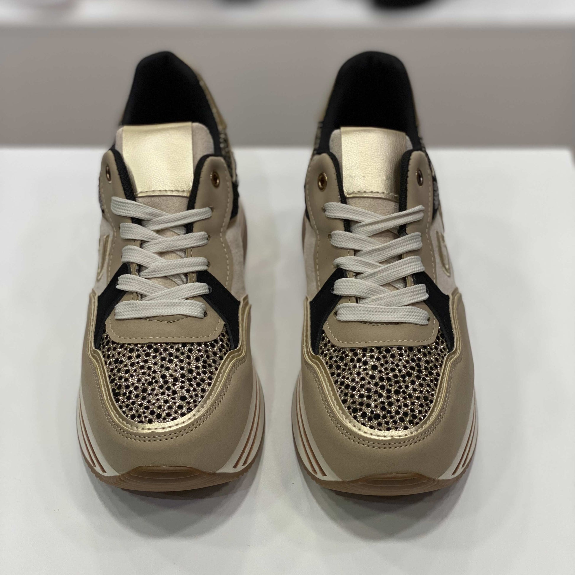 Sneakers beige con glitter e rifiniture dorate, vista frontale su sfondo neutro per mostrare il design accattivante