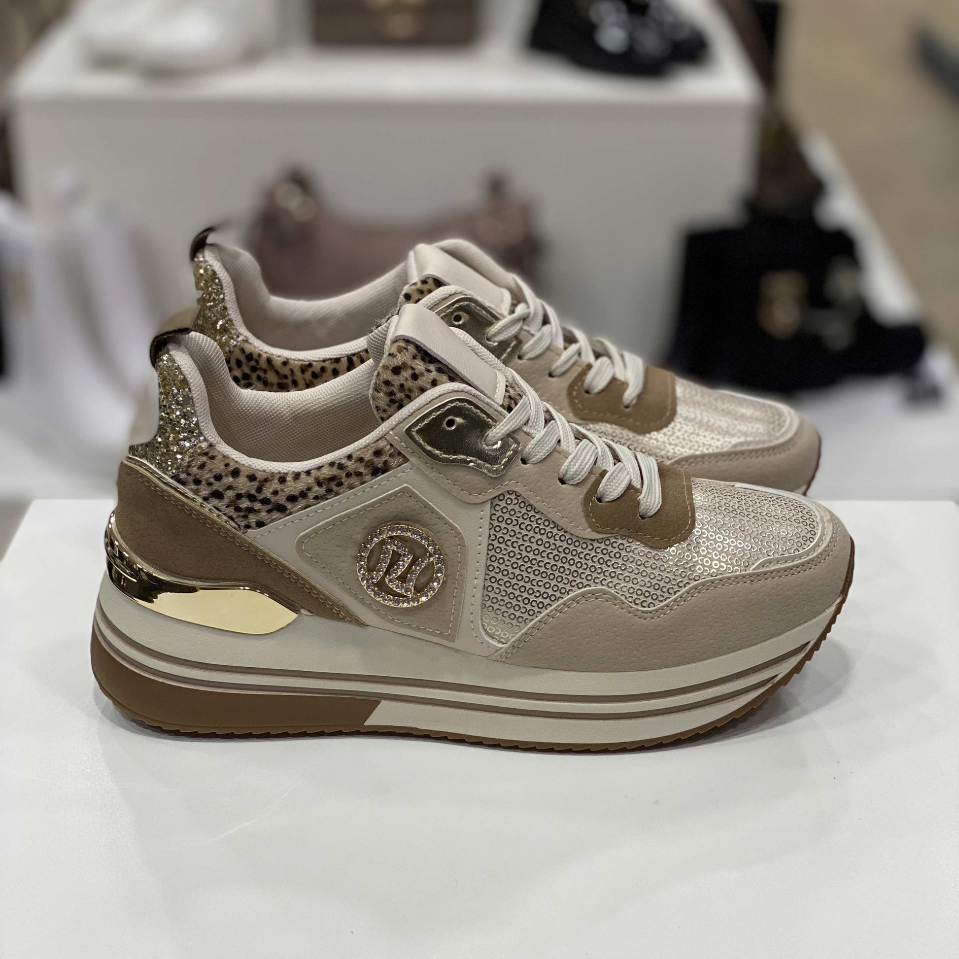 Sneakers beige con glitter dorati e dettagli animalier, vista laterale su sfondo neutro