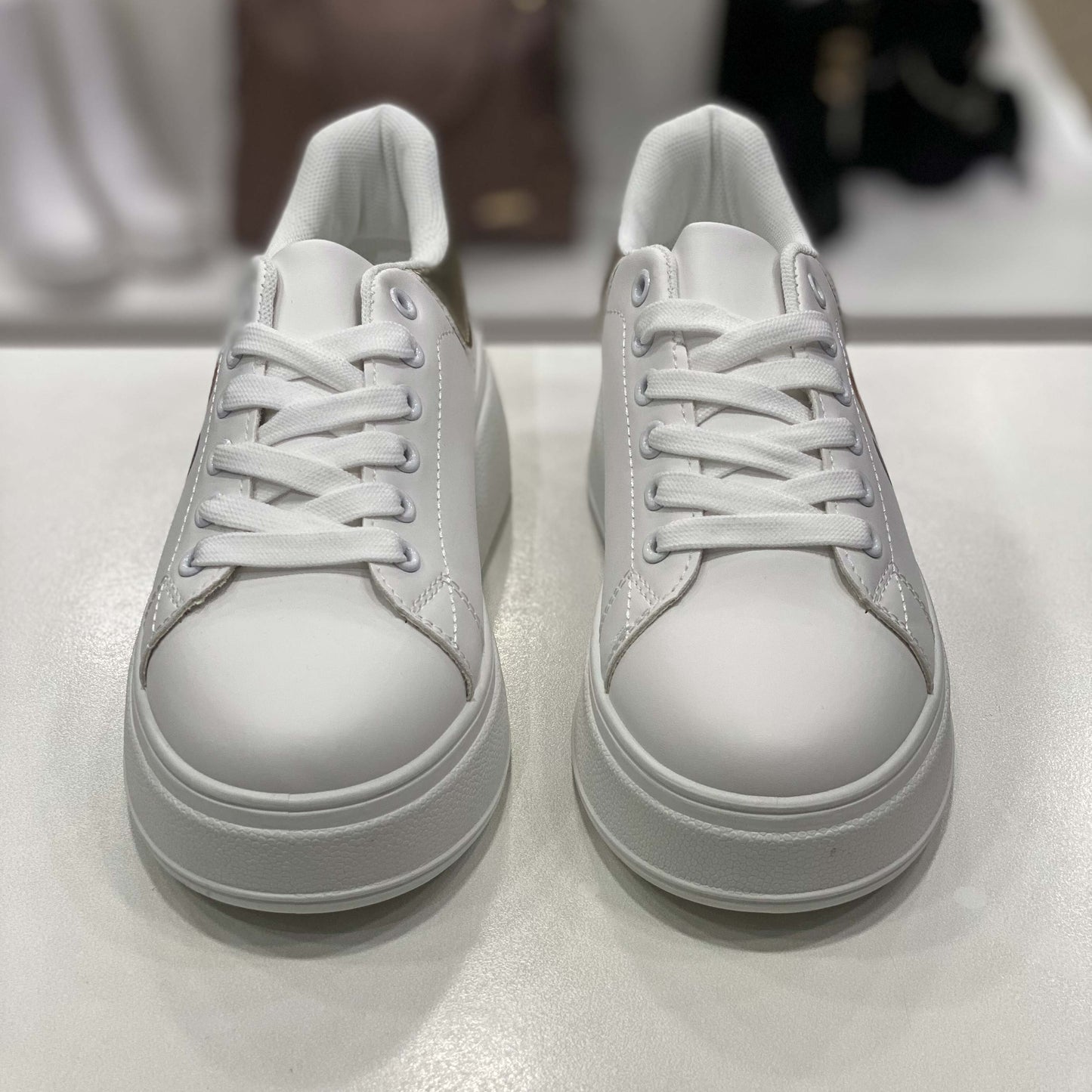 Sneakers bianche con dettaglio oro sul tallone e stampa orsetto, vista frontale su sfondo neutro