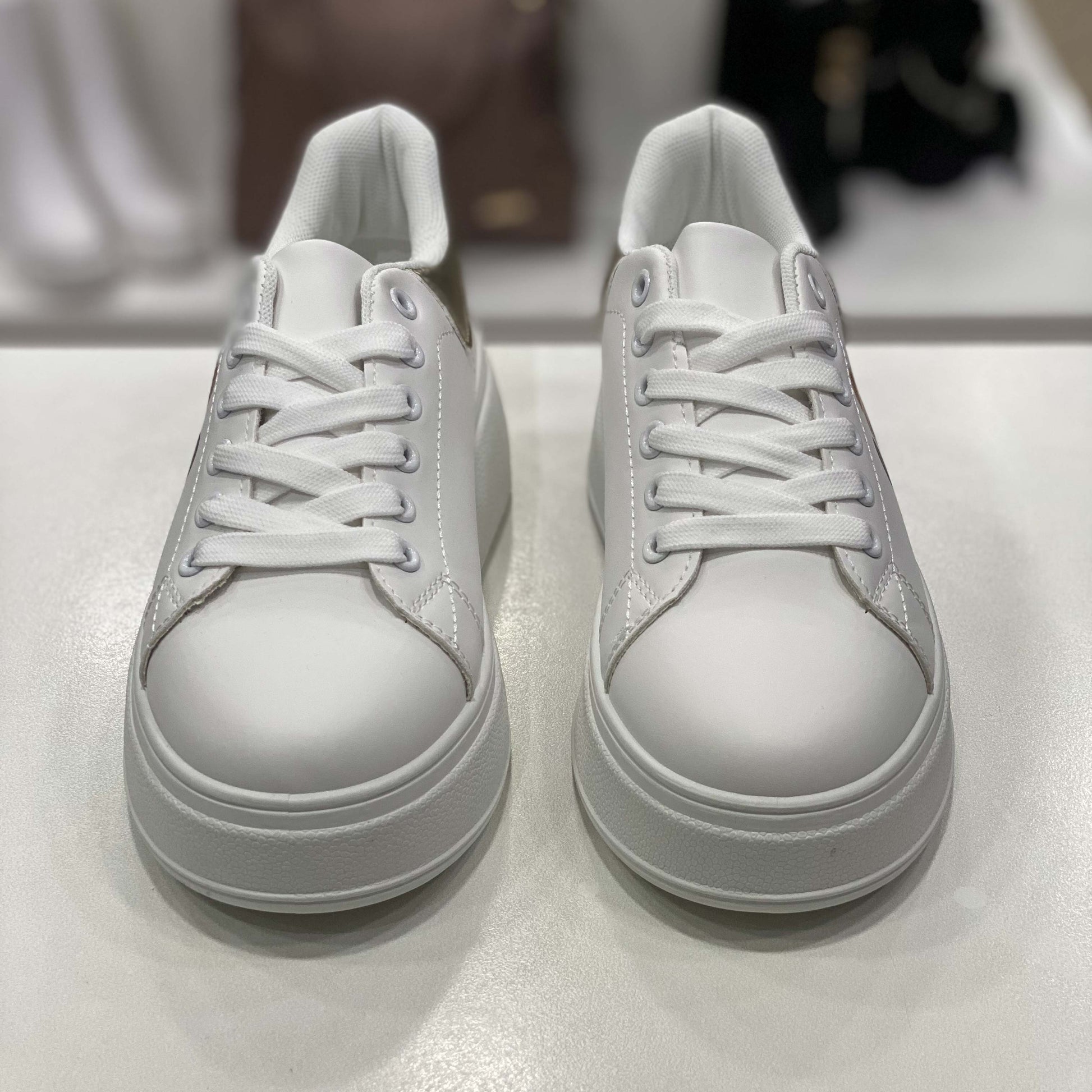 Sneakers bianche con dettaglio oro sul tallone e stampa orsetto, vista frontale su sfondo neutro