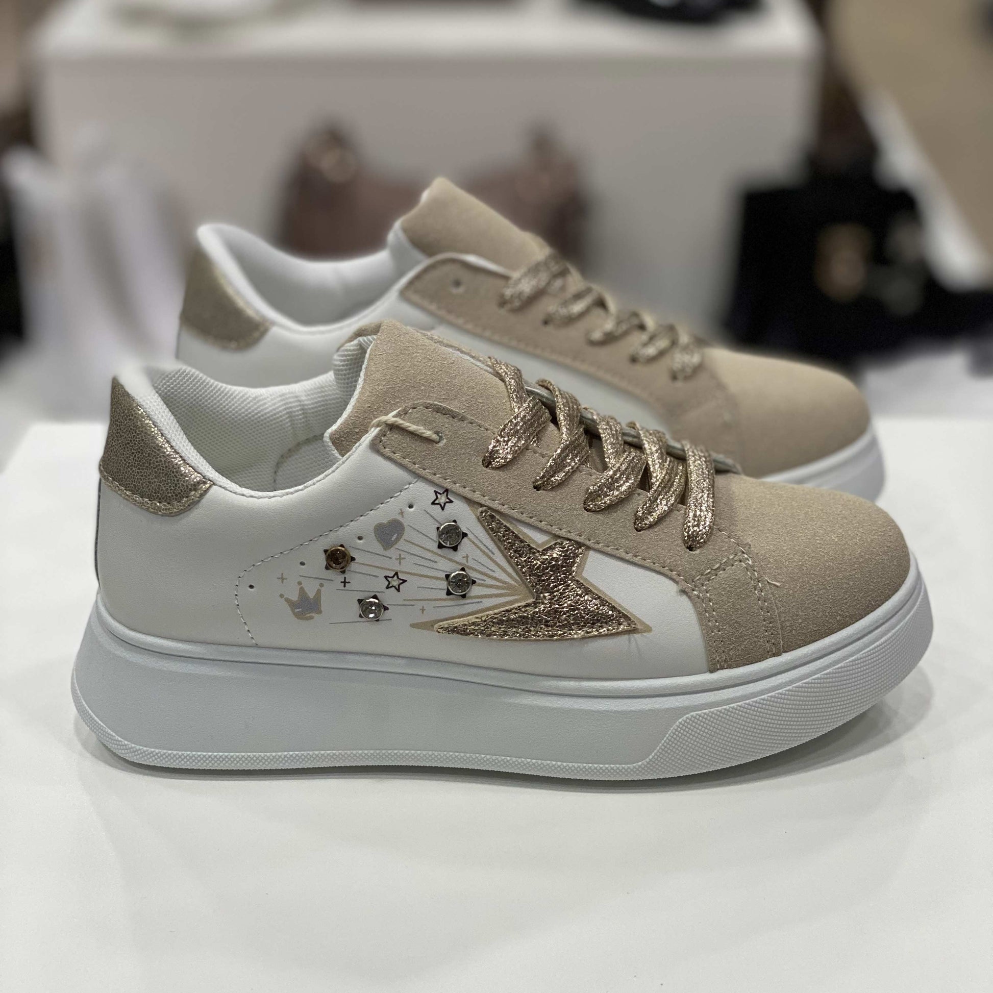 Sneakers beige con stella glitterata dorata, dettagli beige e decorazioni colorate, vista laterale su sfondo neutro