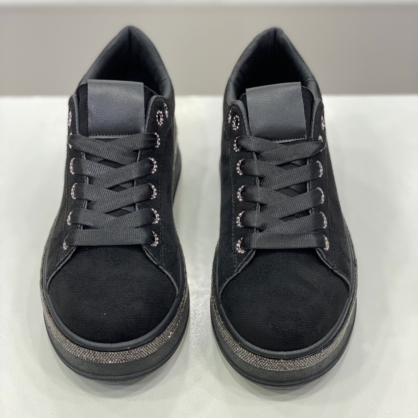 Sneakers nera in camoscio con suola glitter, vista frontale su sfondo neutro