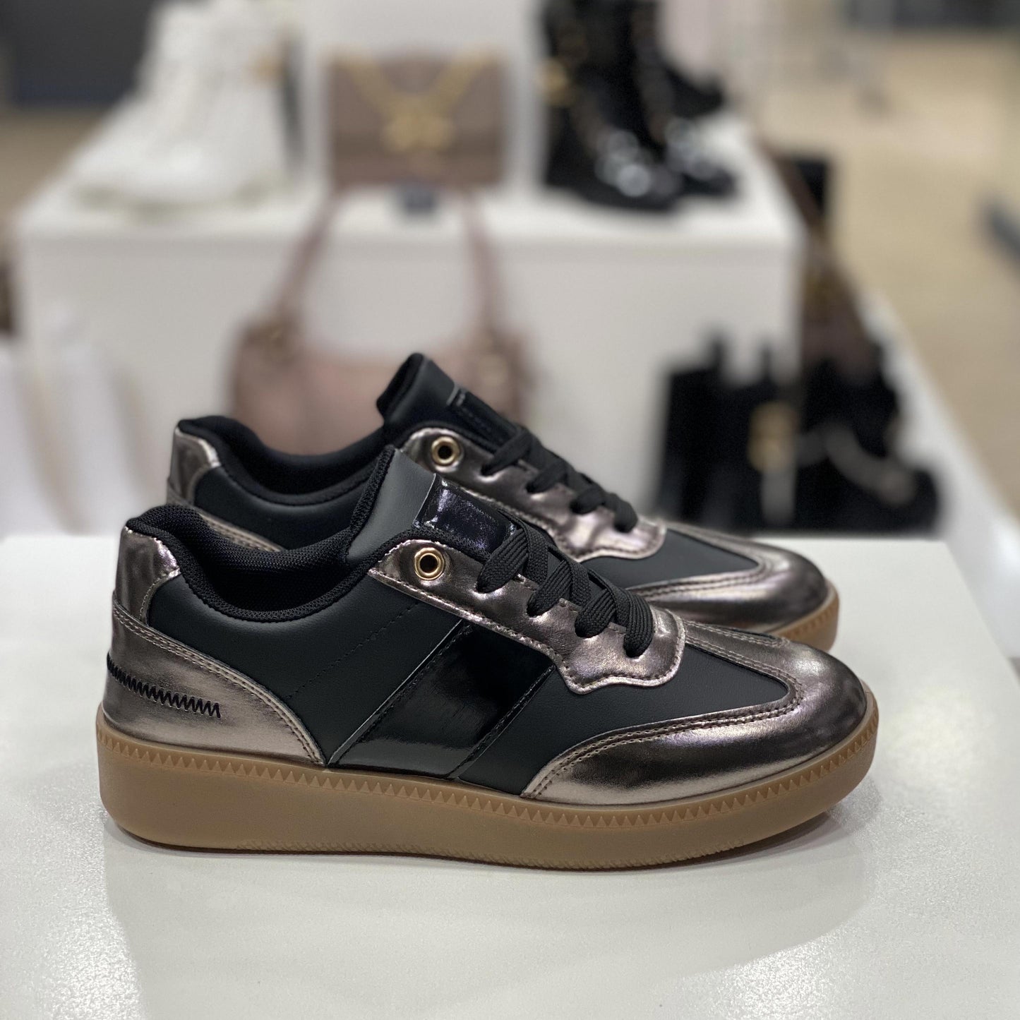 Sneakers nere con dettagli metallizzati color bronzo e suola in gomma, vista laterale per mostrare i dettagli del design