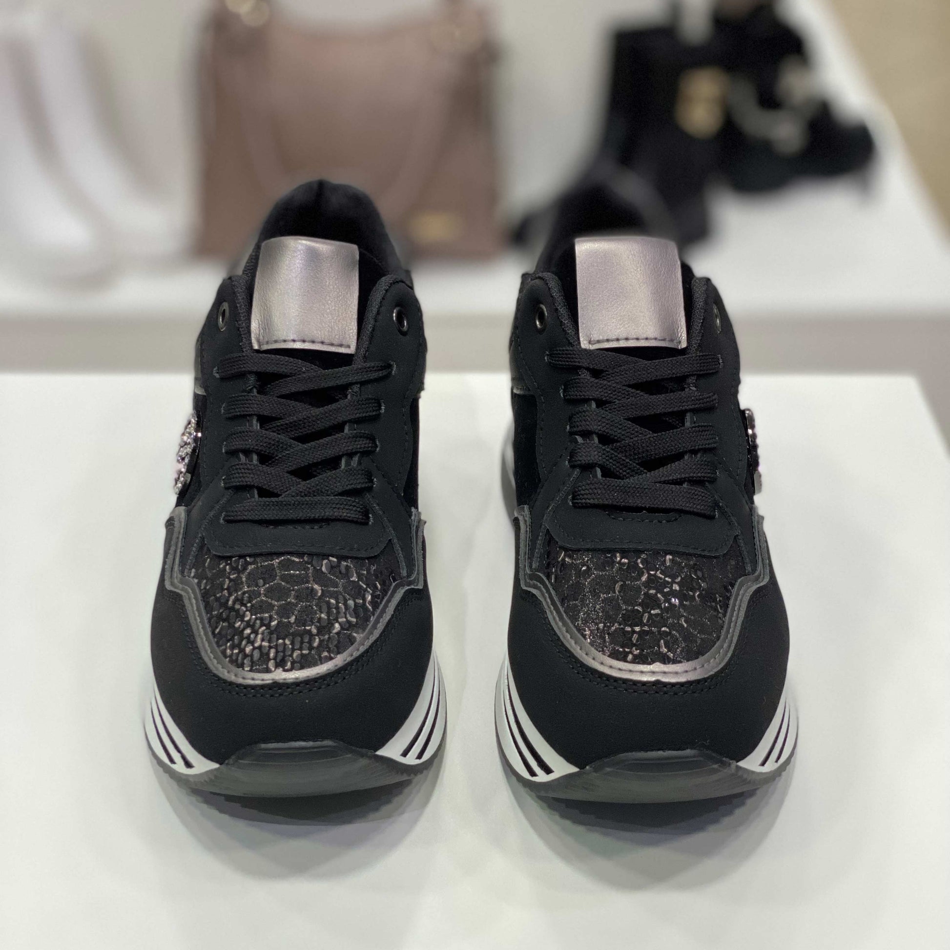 Sneakers nere con strass e dettagli argentati, vista frontale su sfondo neutro